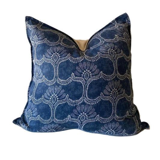 Blue patterned pillow on a white surface with a Plain bcking