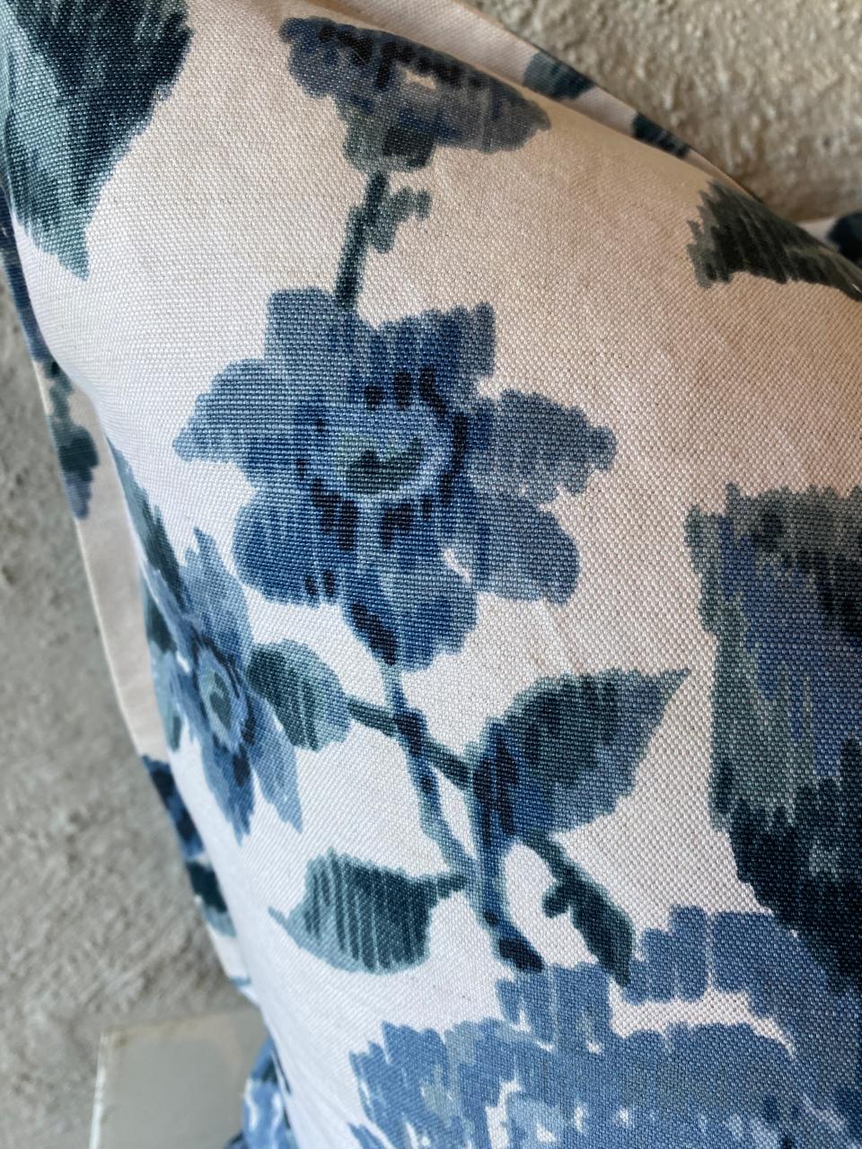 Close-up of a floral patterned fabric with blue flowers on a beige background