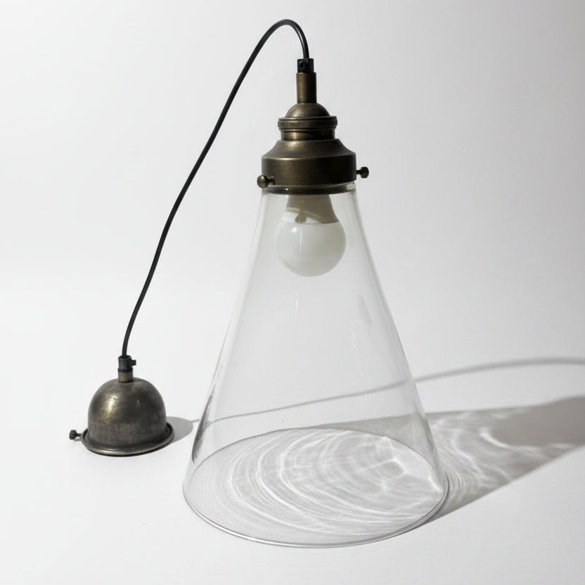 Vintage-style pendant light with a glass shade on a textured white background