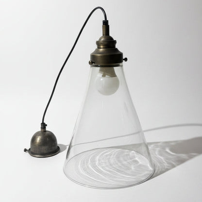 Vintage-style pendant light with a glass shade on a textured white background