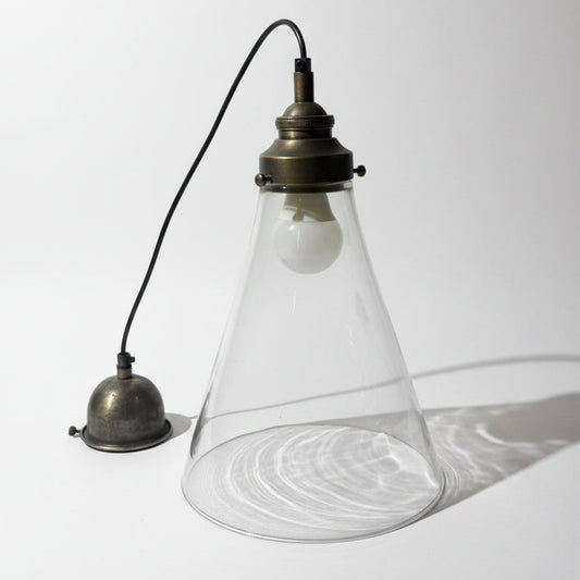 Vintage-style pendant light with a glass shade on a textured white background