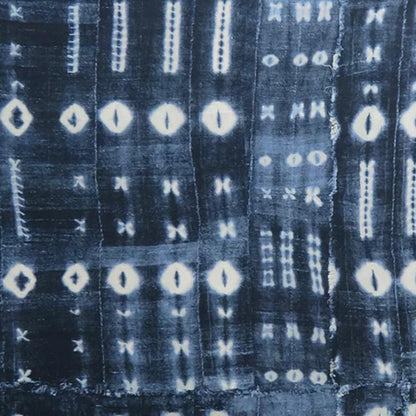 Close-up of a textured fabric with a pattern of white shapes on a dark blue background