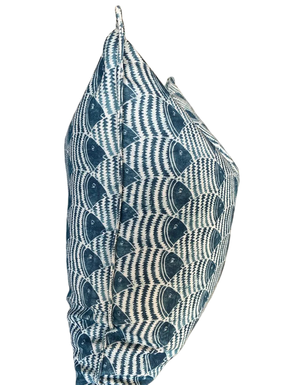 Textured blue and white patterned pillow on a surface with a neutral background