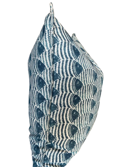 Textured blue and white patterned pillow on a surface with a neutral background