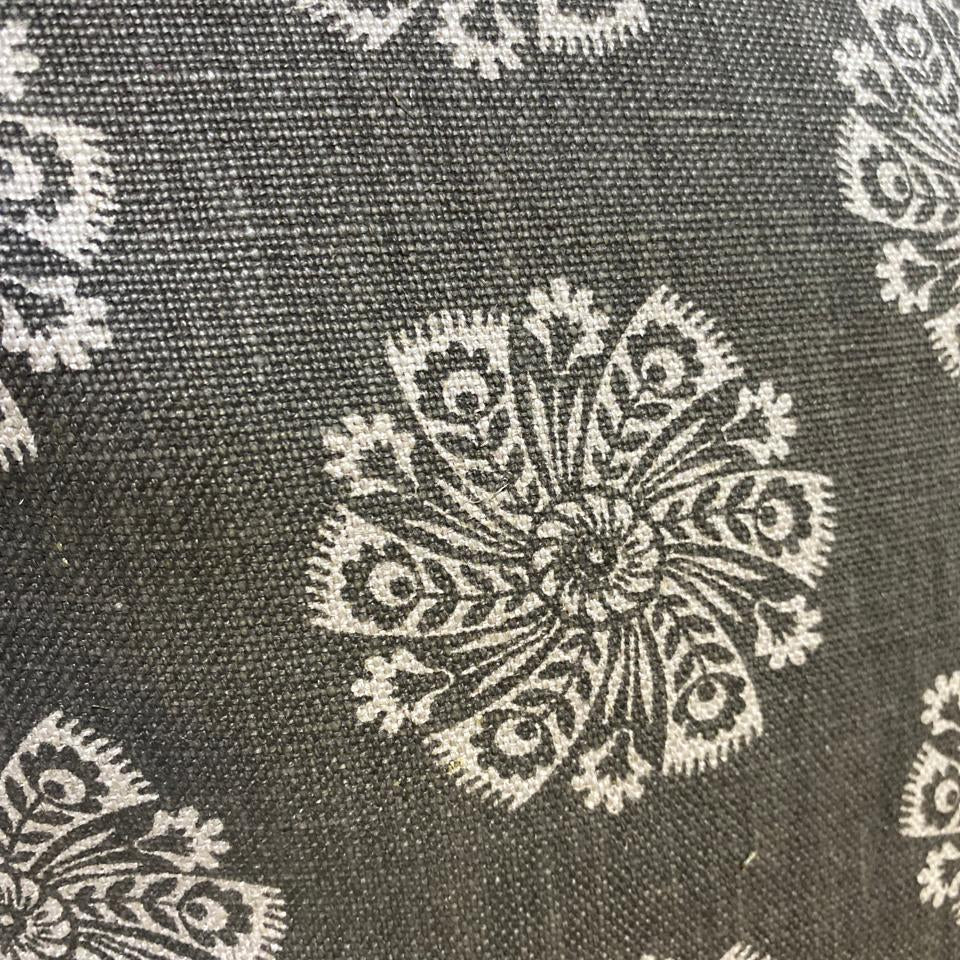 Close-up of fabric with intricate white floral patterns on a dark background