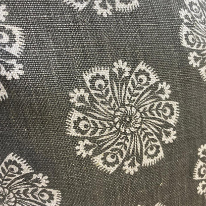 Close-up of fabric with intricate white floral patterns on a dark background