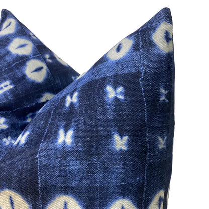 Blue patterned pillow with white accents on a neutral background