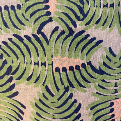 Fabric with a leaf pattern in green and navy on a beige background